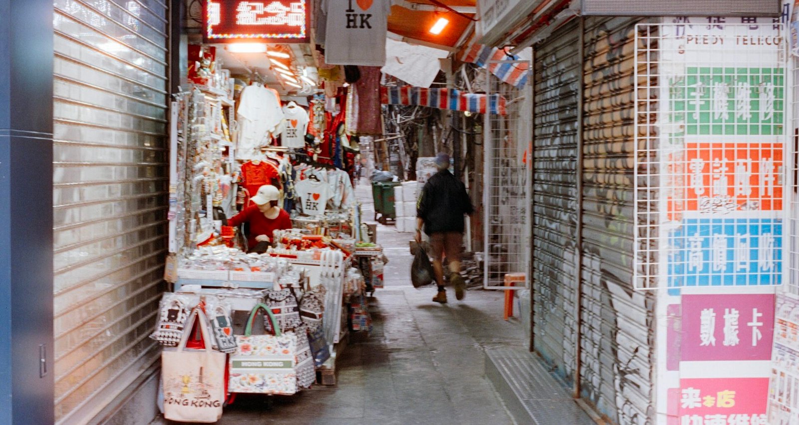Person läuft durch eine enge Marktgasse mit Geschäften auf Mallorca, aufgenommen von Zhen Yao