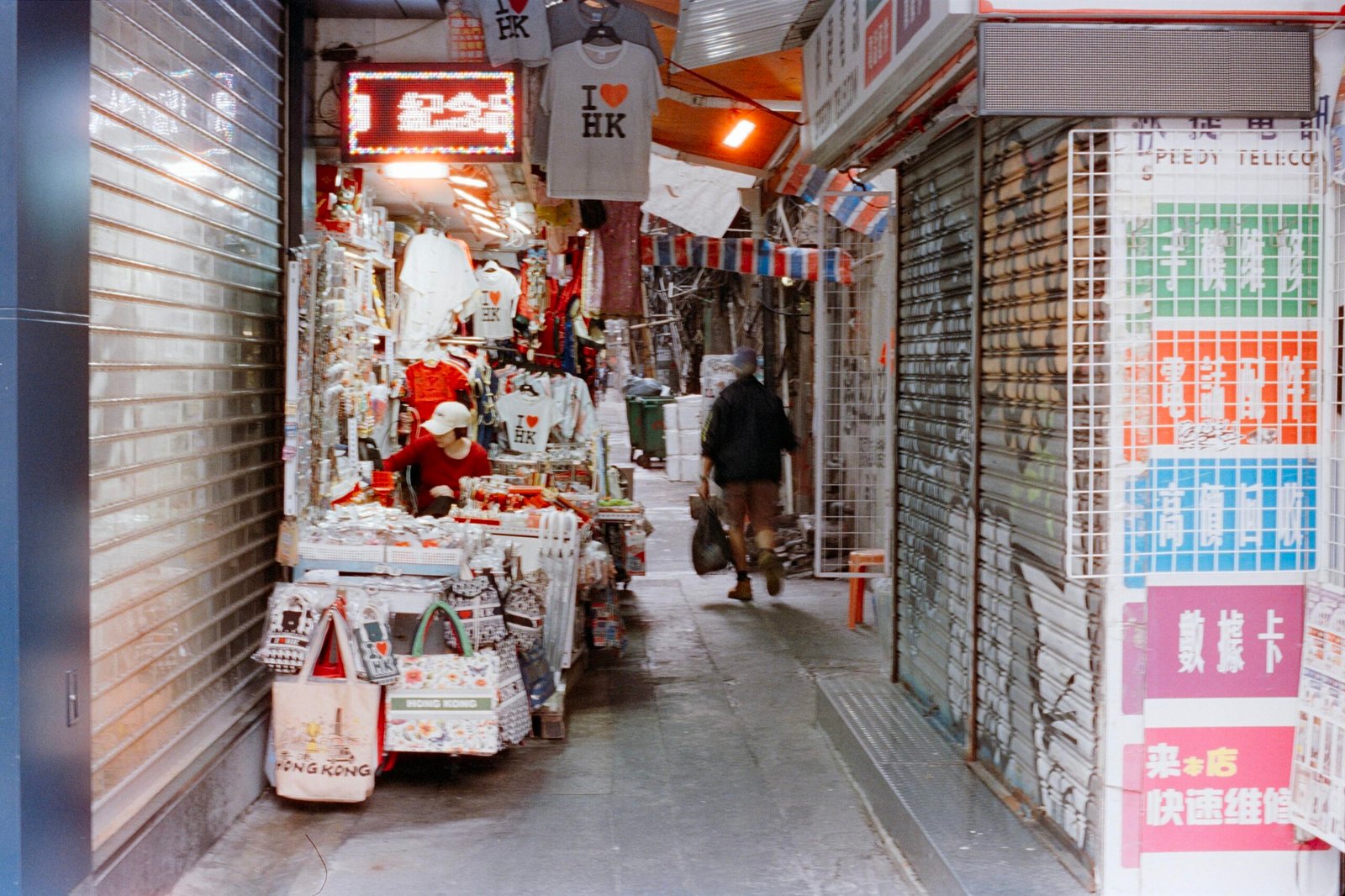 Person läuft durch eine enge Marktgasse mit Geschäften auf Mallorca, aufgenommen von Zhen Yao