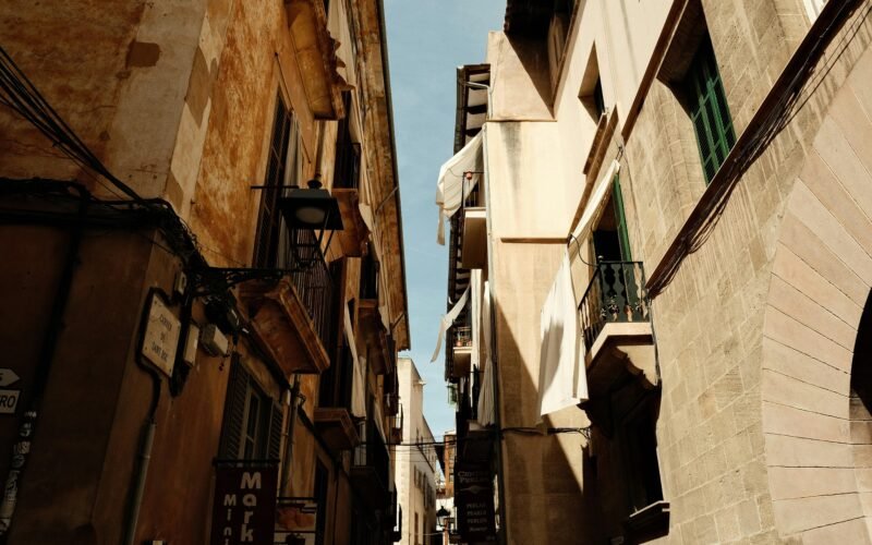 Narrow city street with Gebäuden und einer Uhr auf Mallorca, aufgenommen von Felix