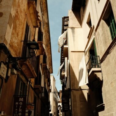 Narrow city street mit Gebäuden und einem Uhrturm auf Mallorca, aufgenommen von Felix.