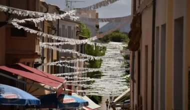 Narrow street lined with buildings and umbrellas auf Mallorca, fotografiert von Jannik