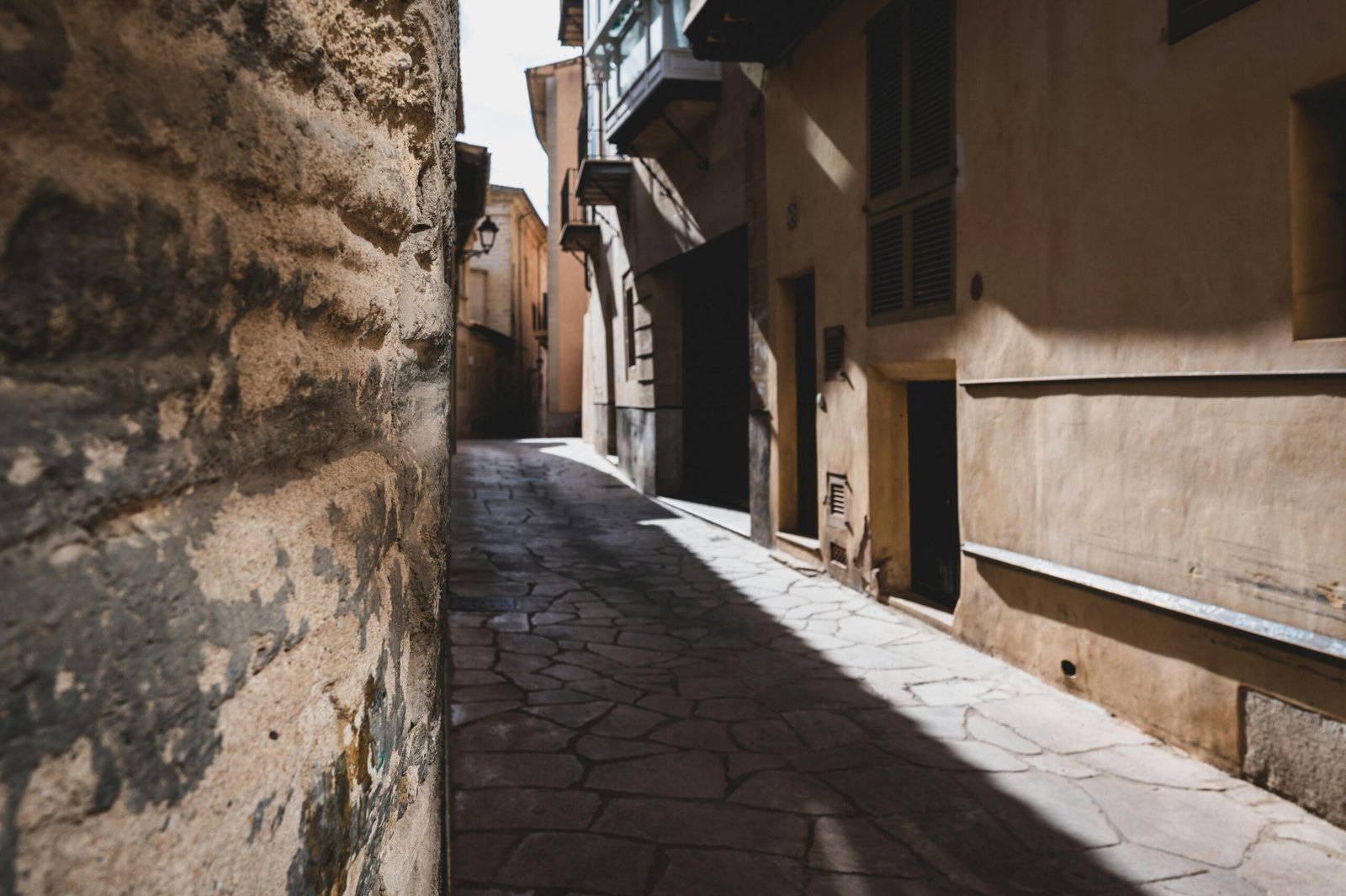 Narrow street with a stone wall and a building auf Mallorca, fotografiert von Bergkinder