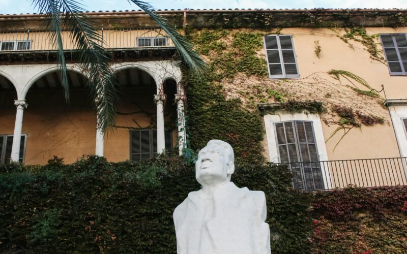 Statue eines Mannes vor einem Gebäude auf Mallorca, aufgenommen von Behnaz