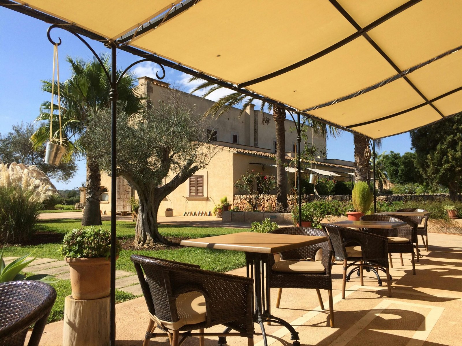 Patio auf Mallorca mit Tischen, Stühlen und einem Sonnenschirm, von Sara Sadeghloo fotografiert