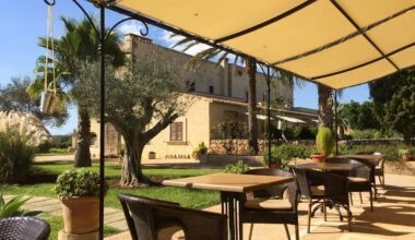 Patio auf Mallorca mit Tischen und Stühlen unter einem Sonnenschirm, perfekt für eine entspannte Atmosphäre