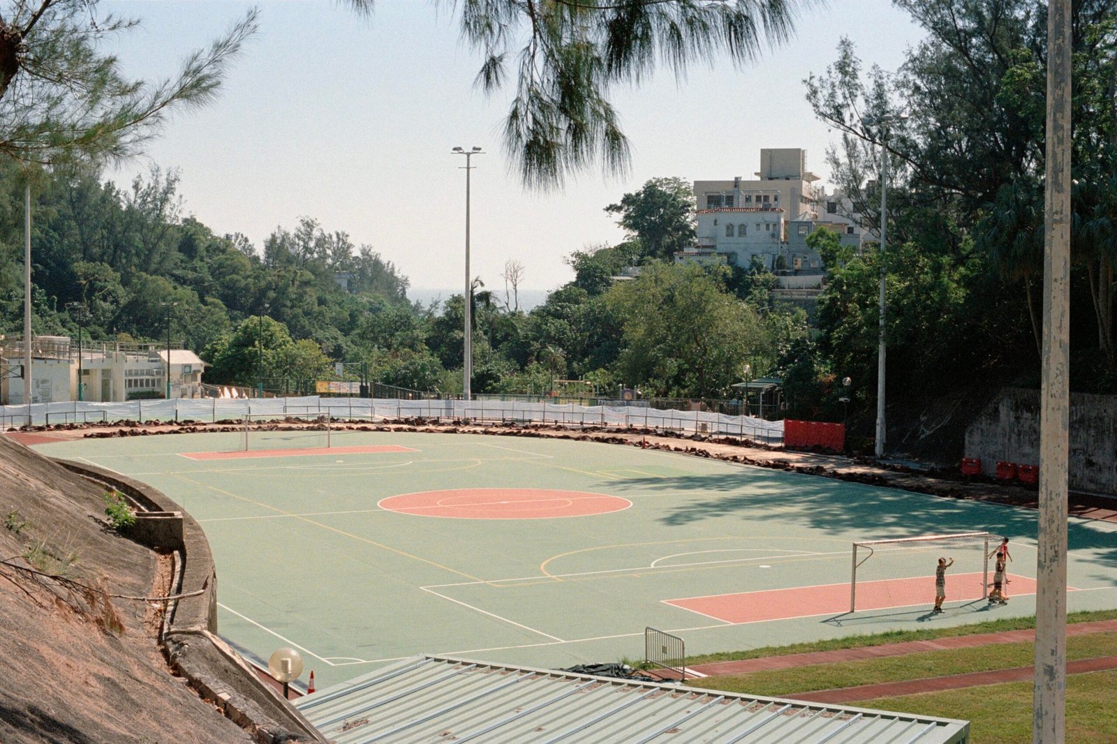 Außenbasketballplatz auf Mallorca mit Bäumen und Gebäuden im Hintergrund, fotografiert von Zhen Yao