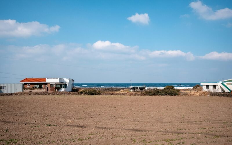 Gebäude nahe dem Ozean auf Mallorca unter einem bewölkten Himmel, fotografiert von hyunwoo jang