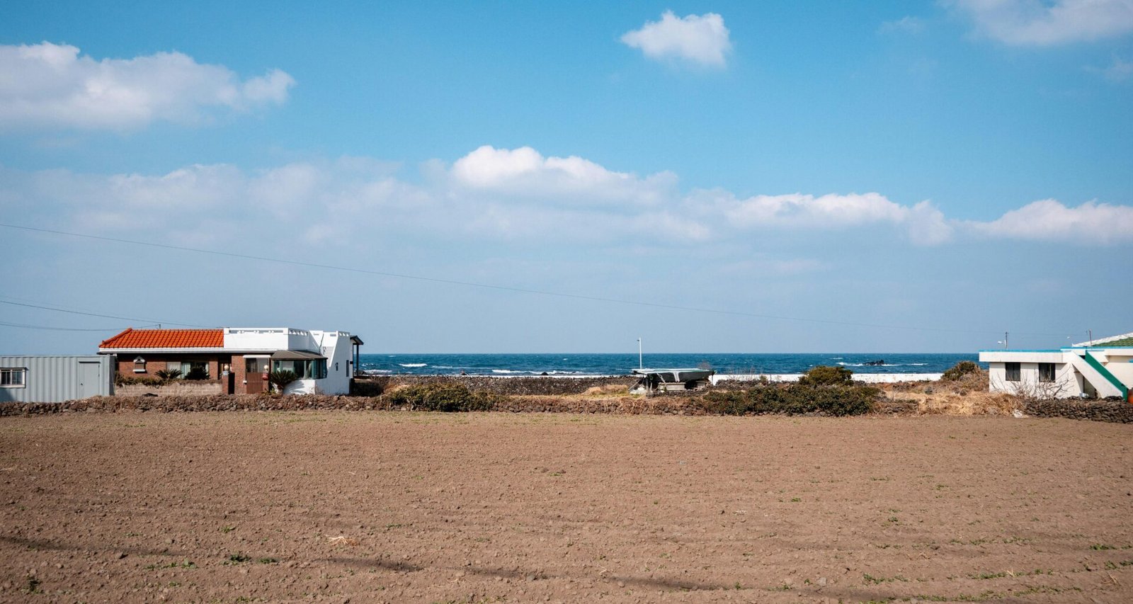 Gebäude nahe dem Meer auf Mallorca unter einem bewölkten Himmel, aufgenommen von hyunwoo jang