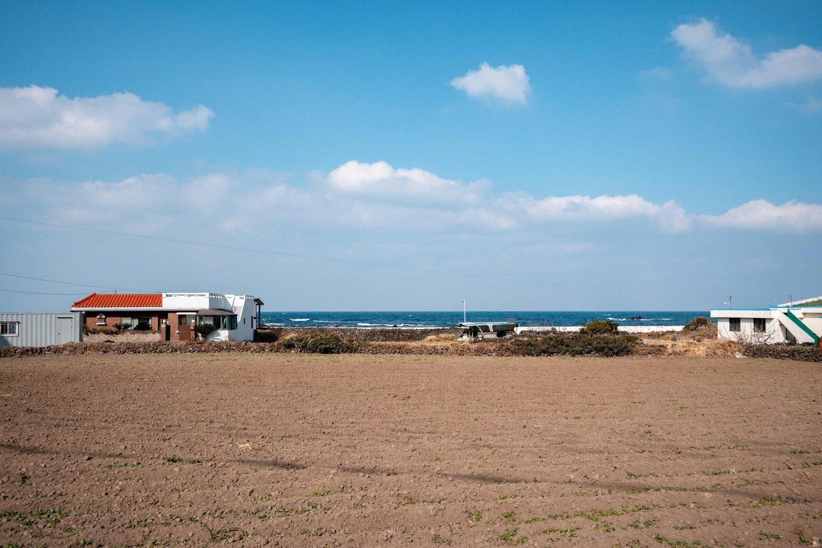 Gebäude nahe dem Meer auf Mallorca unter einem bewölkten Himmel, aufgenommen von hyunwoo jang