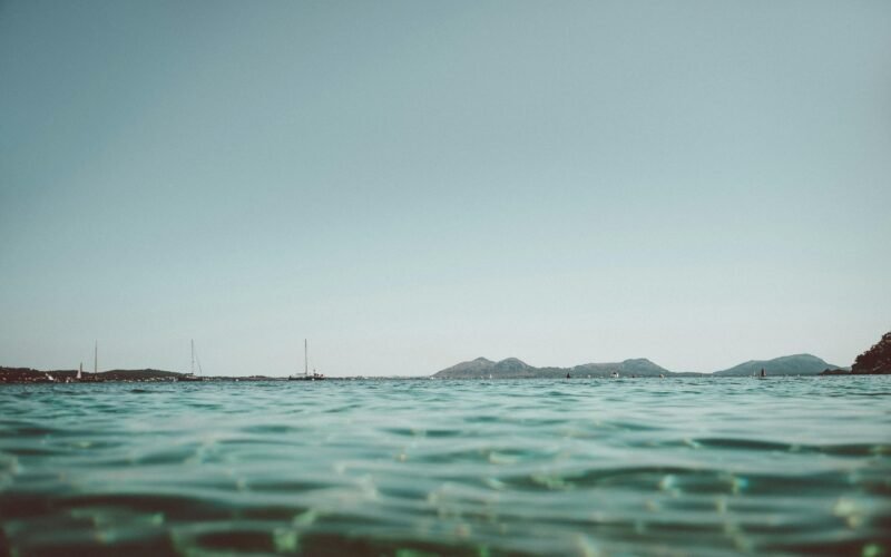 Blick auf das ruhige Wasser auf Mallorca, aufgenommen von Tobias, mit sanften Wellen und natürlicher Umgebung.