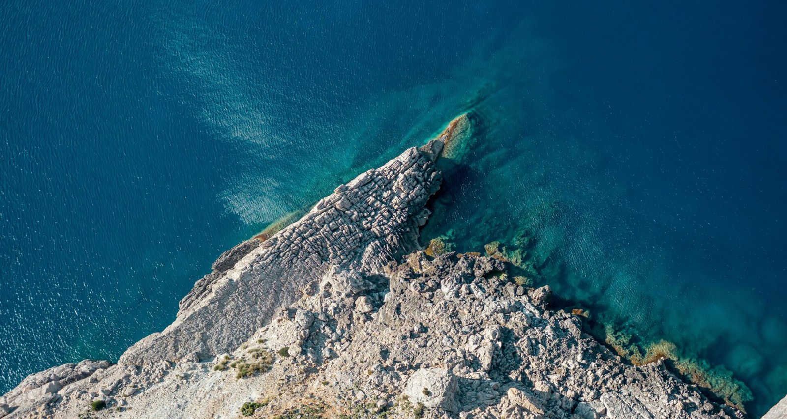 Klares Wasser nahe einer Insel auf Mallorca, aufgenommen von Christian Waske, mit Blick auf die ruhige Meeresoberfläche.