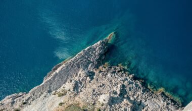 Klares Wasser nahe einer Insel auf Mallorca, aufgenommen von Christian Waske, mit Blick auf die ruhige Meeresoberfläche.