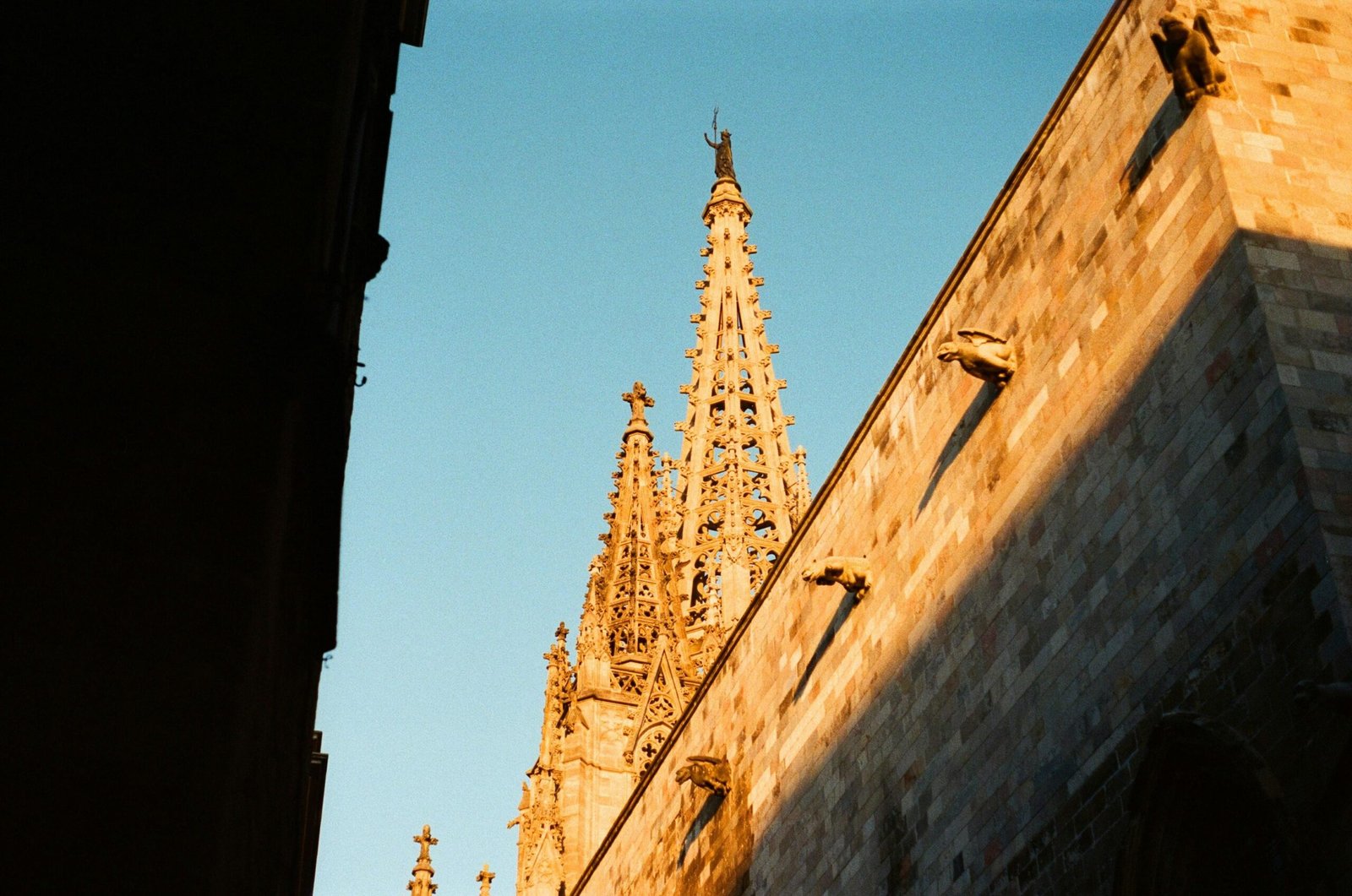 Gothischer Kirchturm mit spitzem Turm gegen einen klaren blauen Himmel auf Mallorca, fotografiert von Maharram Hasanli