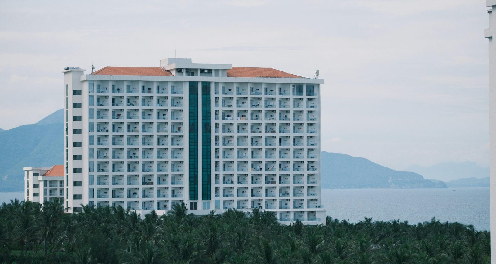 Großes weißes Hotelgebäude auf Mallorca mit Blick auf den Ozean, aufgenommen von Duc Van.