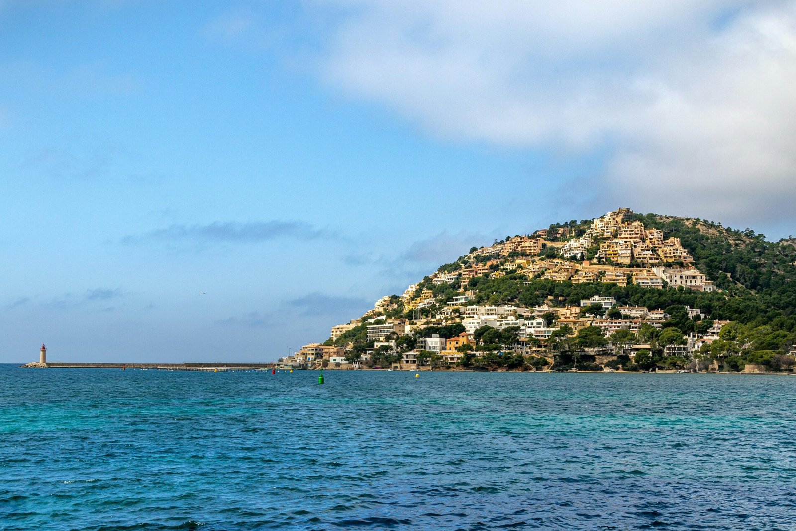 Grüne und braune Felsformation am Meer auf Mallorca unter blauem Himmel während des Tages