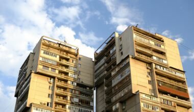 Tall brutalist apartment buildings against a blue sky on Mallorca, aufgenommen von Muhammet Cengiz.