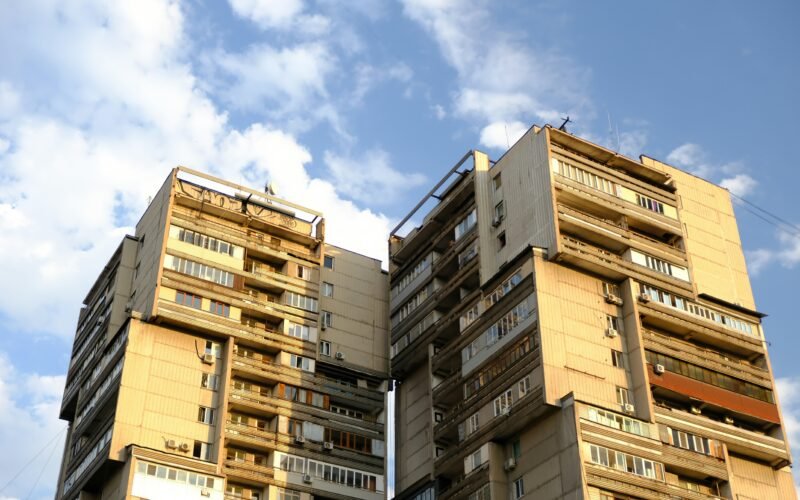 Tall brutalist apartment buildings against a blue sky on Mallorca, aufgenommen von Muhammet Cengiz.