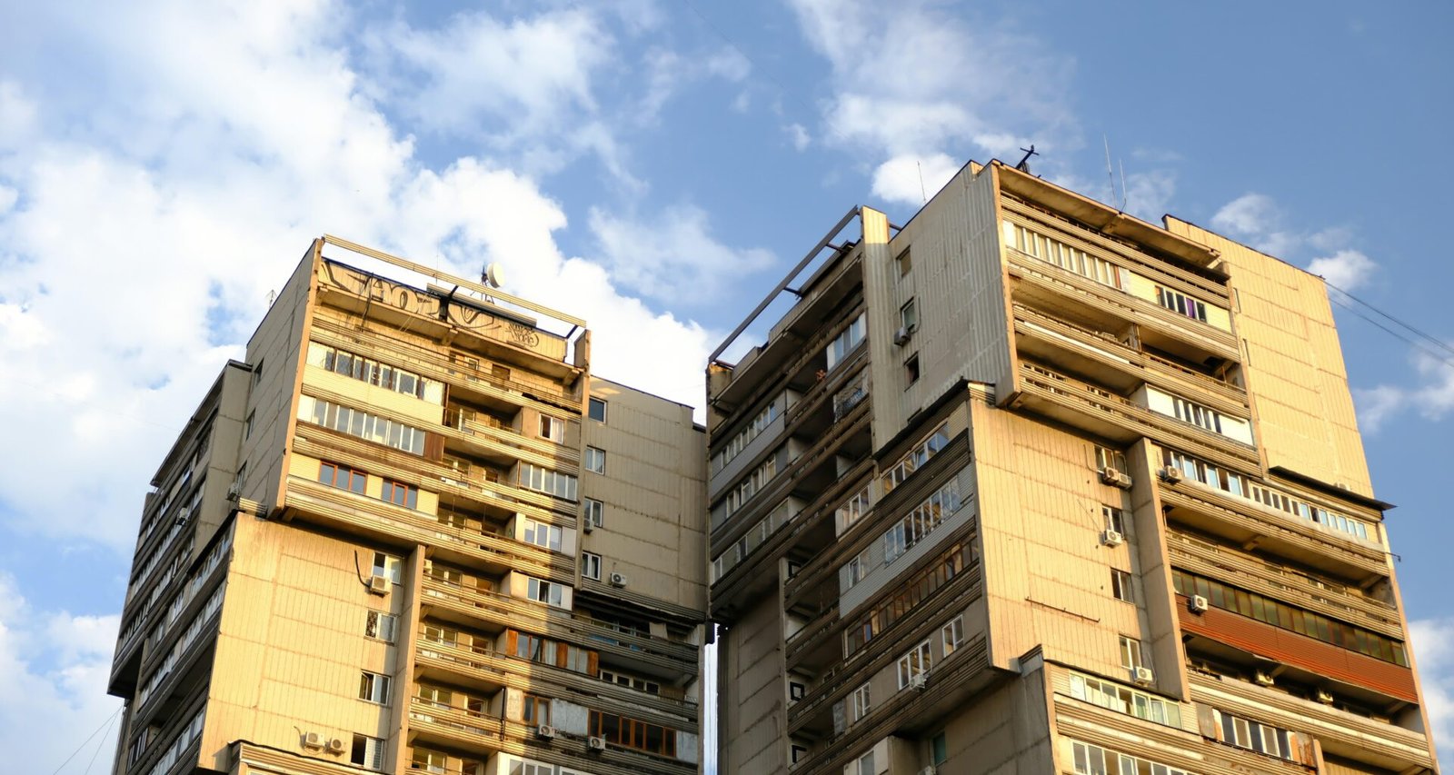 Tall brutalist apartment buildings against a blue sky on Mallorca, photographed by Muhammet Cengiz.