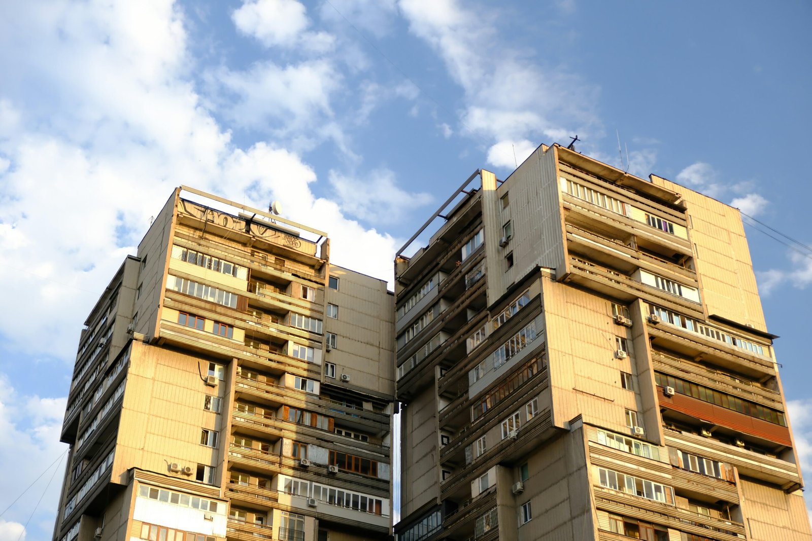 Tall brutalist apartment buildings against a blue sky on Mallorca, photographed by Muhammet Cengiz.