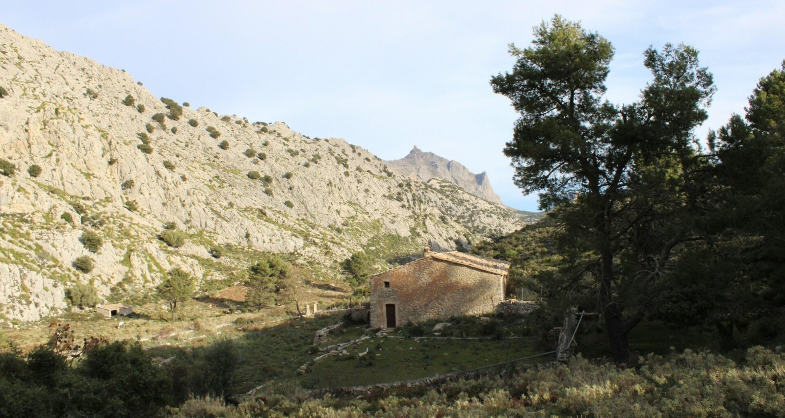 Steinernes Gebäude steht vor einer Bergkulisse auf Mallorca, aufgenommen von Susana Bartolome.