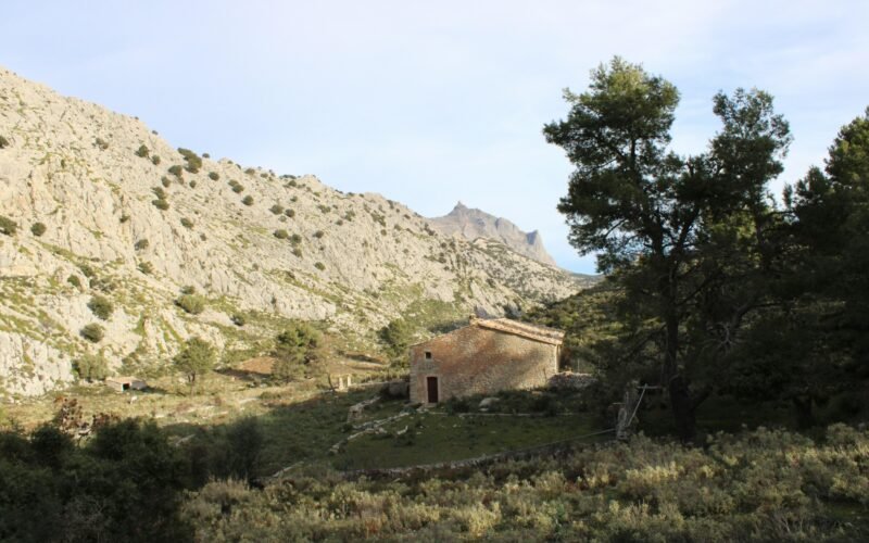 Steinernes Gebäude steht vor einer Bergkulisse auf Mallorca, aufgenommen von Susana Bartolome.