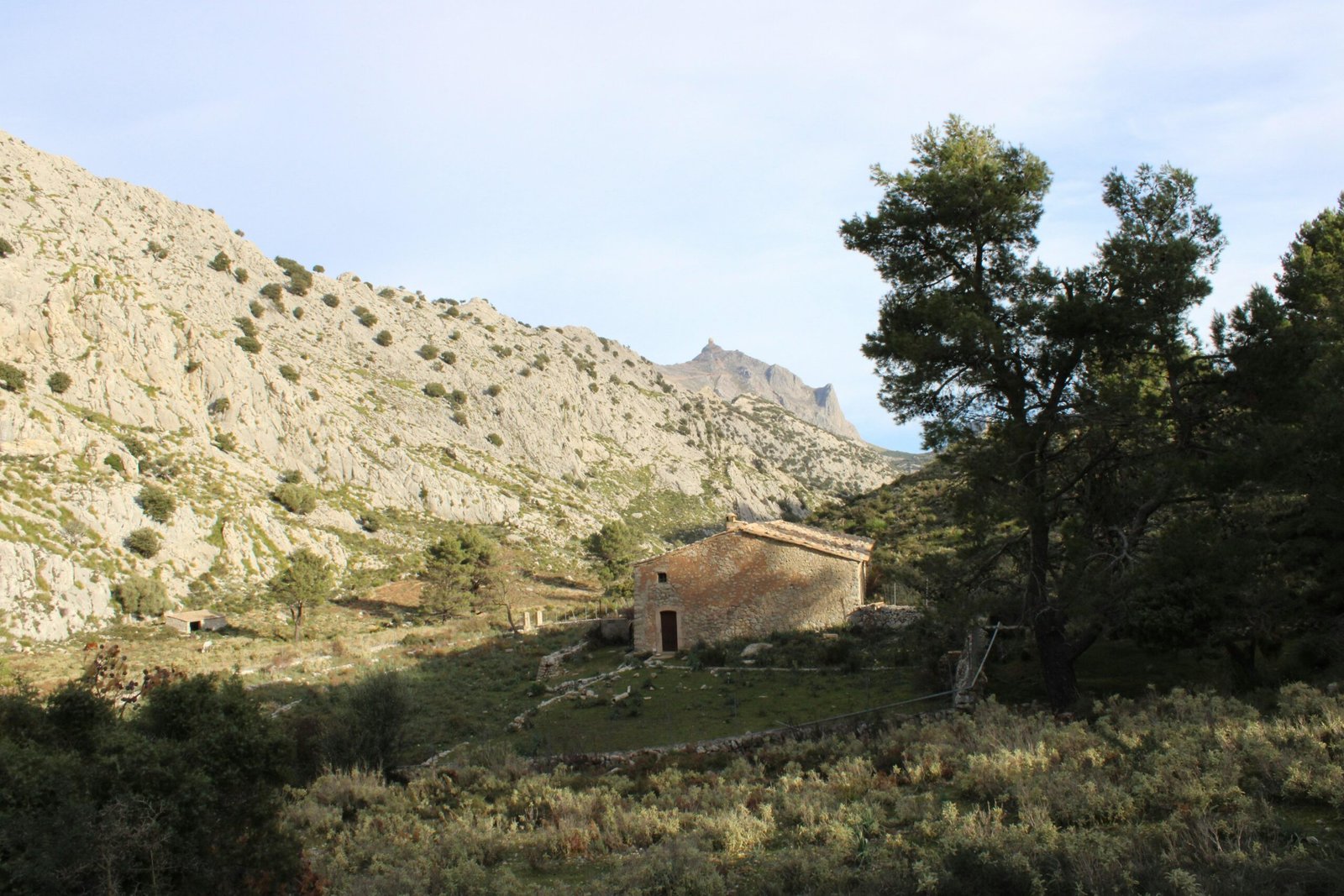 Steinernes Gebäude steht vor einer Bergkulisse auf Mallorca, aufgenommen von Susana Bartolome.