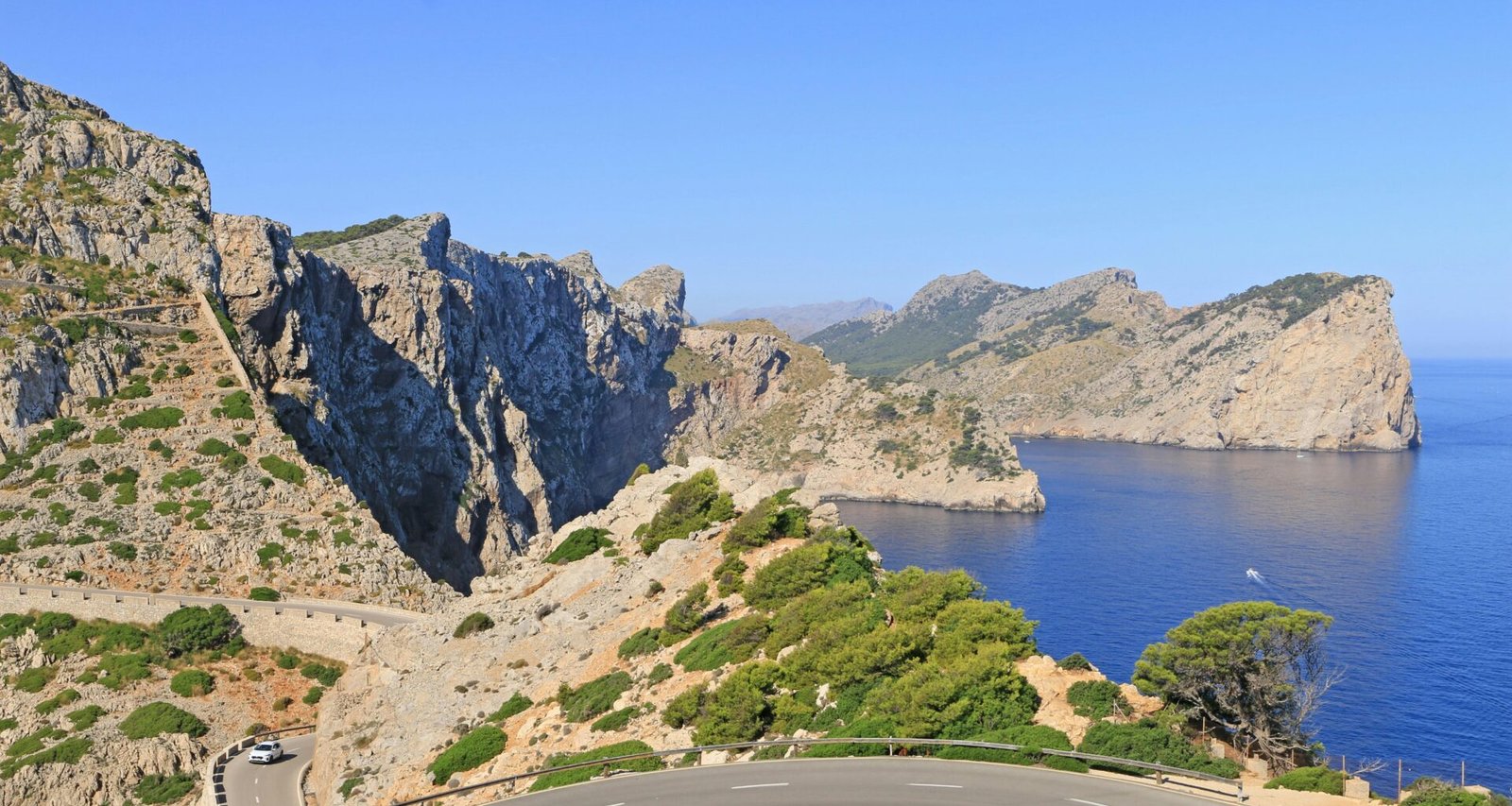 Winding road entlang einer zerklüfteten Küste mit blauem Meer auf Mallorca, fotografiert von Luis Gonçalves.