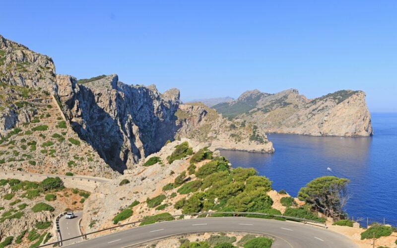 Winding road entlang einer zerklüfteten Küste mit blauem Meer auf Mallorca, fotografiert von Luis Gonçalves.