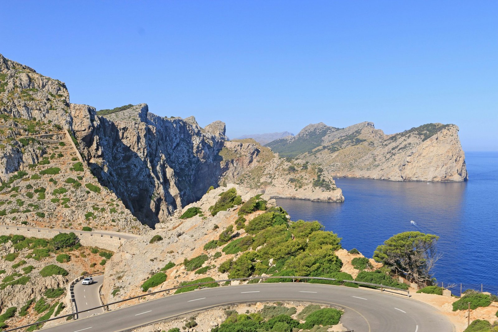 Winding road entlang einer zerklüfteten Küste mit blauem Meer auf Mallorca, fotografiert von Luis Gonçalves.