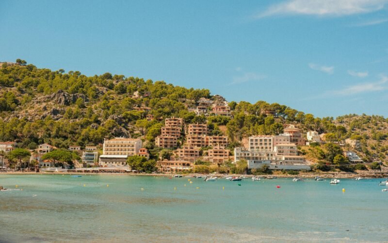 Küstenort auf Mallorca am Hang mit Bäumen und Blick aufs Meer, fotografiert von Alexis Presa