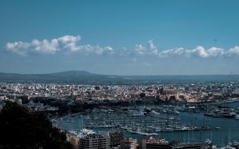 Luftaufnahme von Stadtgebäuden nahe einem Gewässer auf Mallorca bei Tageslicht, aufgenommen von Matt Roskovec.