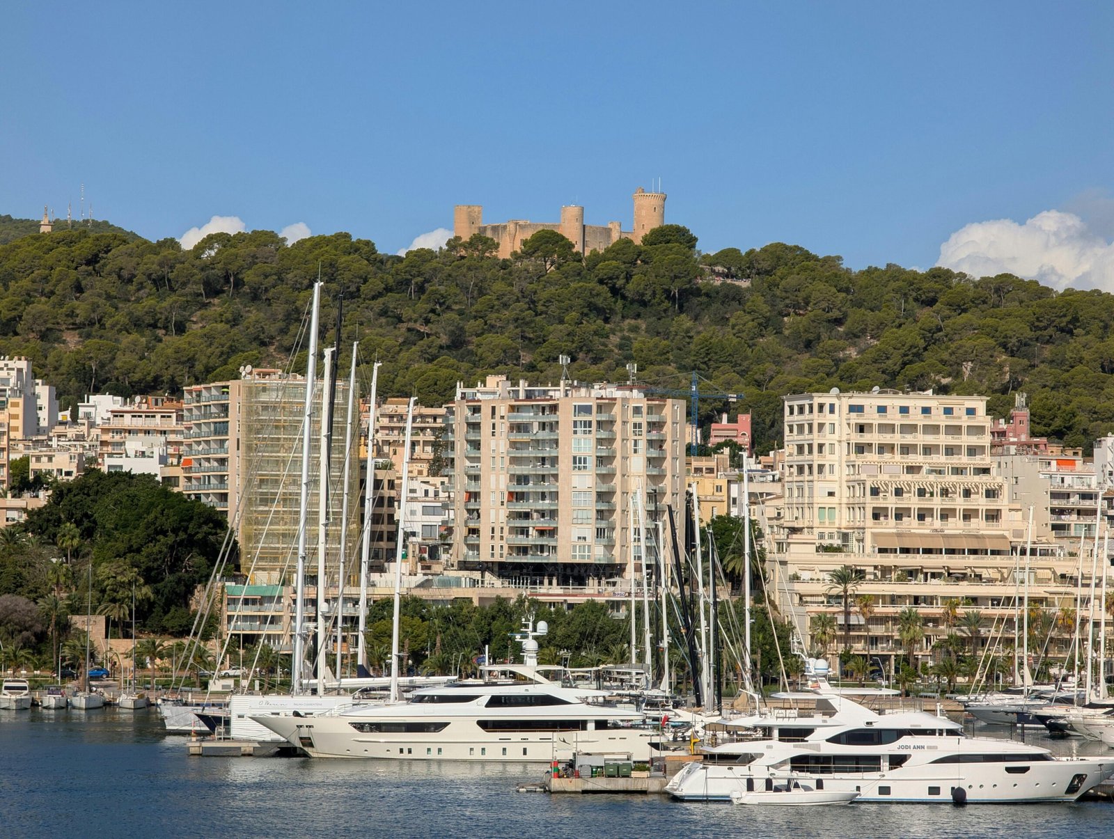 Luxusyachten im Hafen auf Mallorca mit Stadt und Burg im Hintergrund, fotografiert von David Vives.