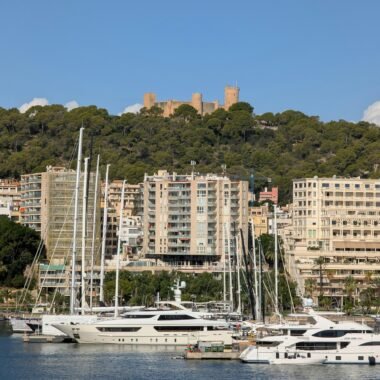 Luxus-Yachten im Hafen auf Mallorca mit Stadt und Burg im Hintergrund, aufgenommen von David Vives