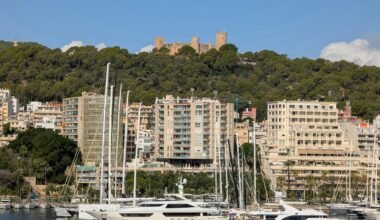 Luxusyachten im Hafen auf Mallorca mit Stadt und Burg im Hintergrund, aufgenommen von David Vives