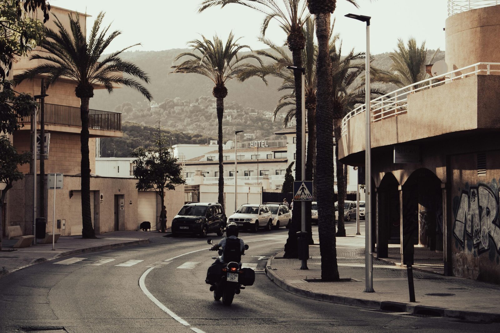 Mann fährt mit Motorrad auf Mallorca während des Tages auf einer Landstraße