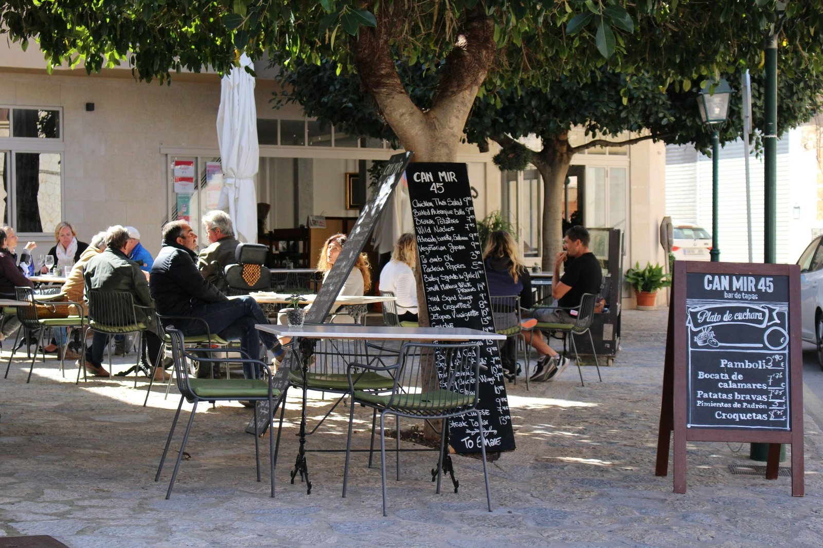 Mann in schwarzer Jacke sitzend auf Mallorca auf einem Stuhl, entspannt und nachdenklich
