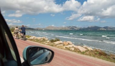 Mann in schwarzer Jacke und blauer Jeans am Seestrand auf Mallorca bei Tageslicht