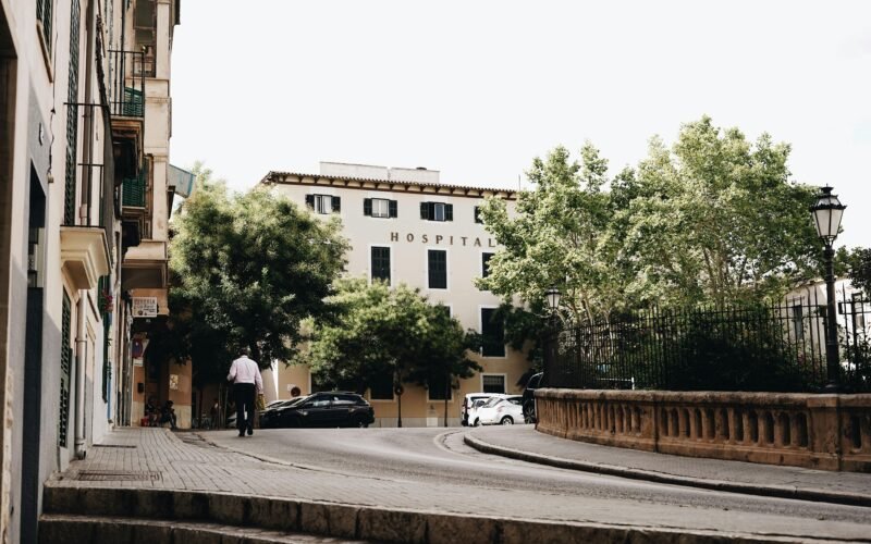 Mann steht neben Autos am Straßenrand auf Mallorca, aufgenommen von Oscar Nord.