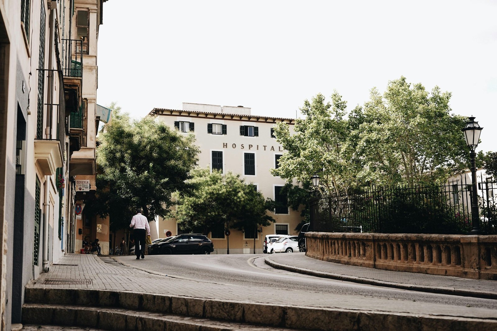 Mann steht neben Autos am Straßenrand auf Mallorca, aufgenommen von Oscar Nord.