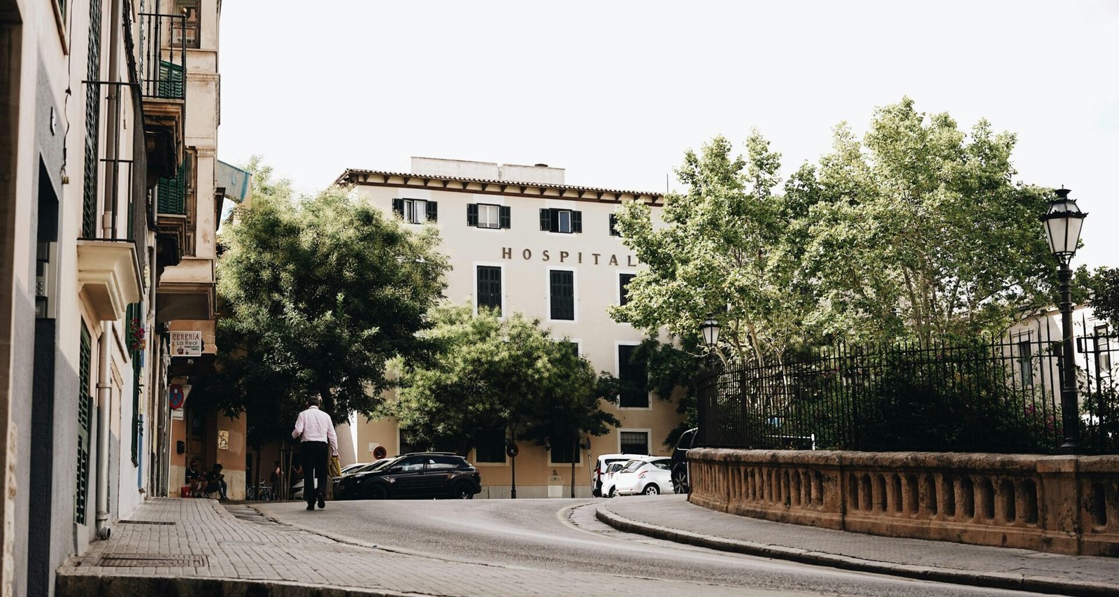 Mann und Autos stehen nahe der Straße auf Mallorca, aufgenommen von Oscar Nord, mit Blick auf die Inselstraße.