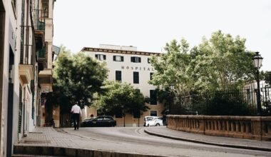 Mann steht neben Autos an einer Straße auf Mallorca, aufgenommen von Oscar Nord.
