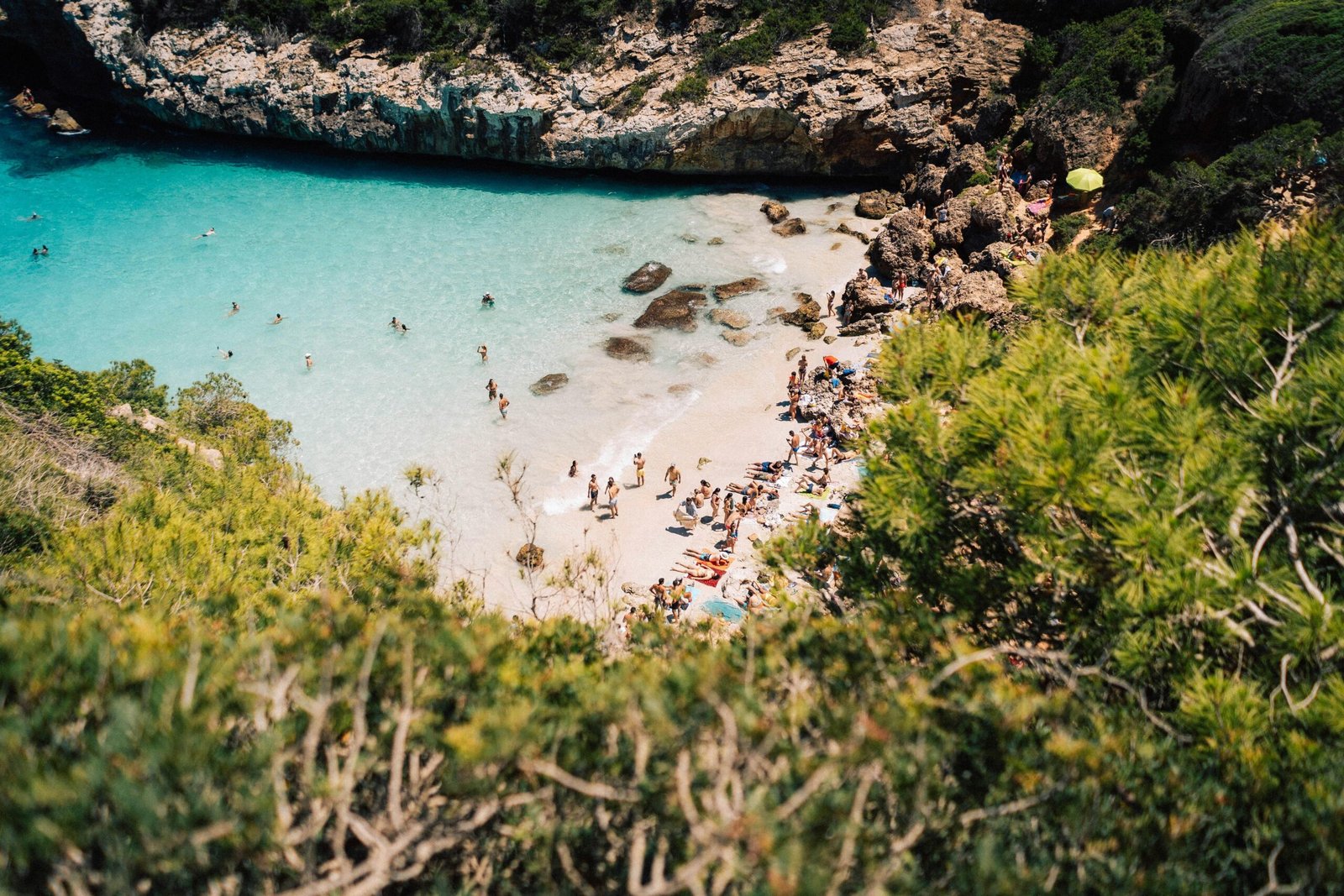 Menschen sitzen und spazieren am Strand auf Mallorca bei Tageslicht, aufgenommen von Fabian S.