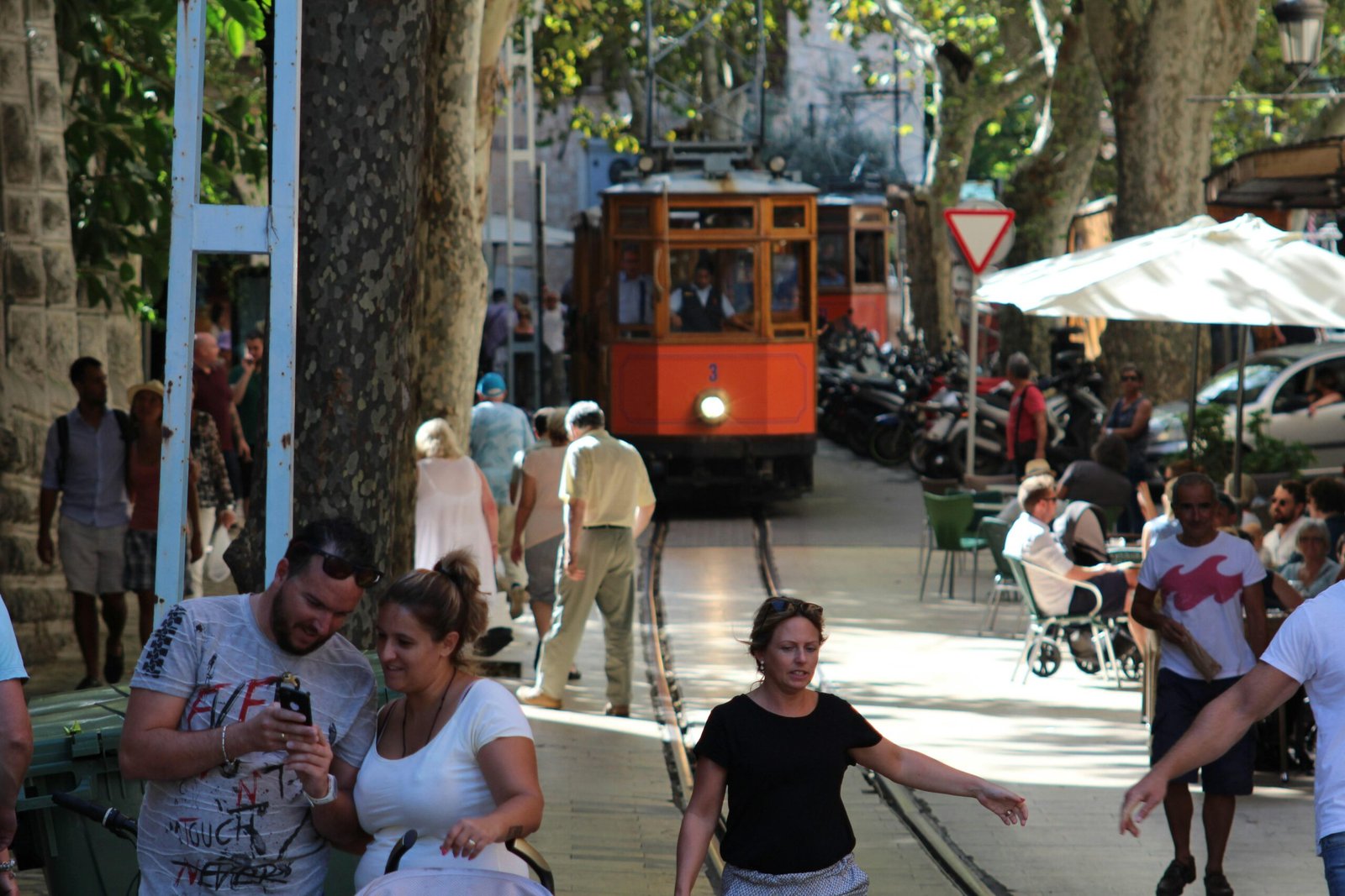 Menschen auf einer belebten Straße auf Mallorca bei Tageslicht, fotografiert von John McFetridge.