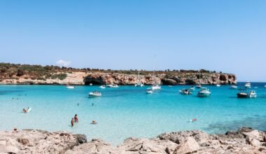 Menschen schwimmen im klaren Wasser auf Mallorca bei Tageslicht, während sie den Strand genießen