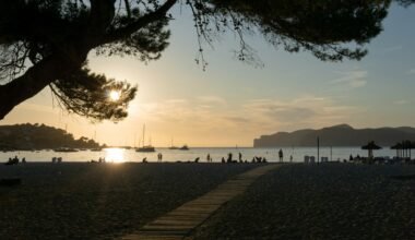 Menschen gehen tagsüber am Wasser entlang auf Mallorca, Spaziergänger auf dem Bürgersteig bei Tageslicht