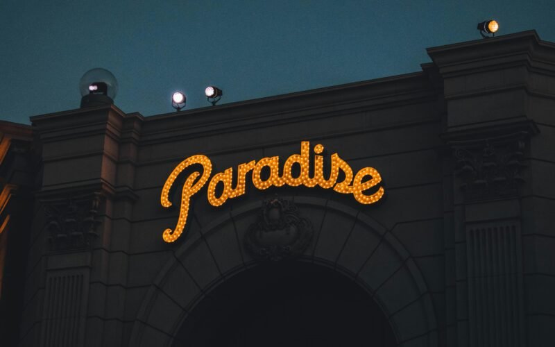 Ein Schild mit der Aufschrift 'Paradise' auf Mallorca, aufgenommen von Roméo A., vor einer natürlichen Kulisse.