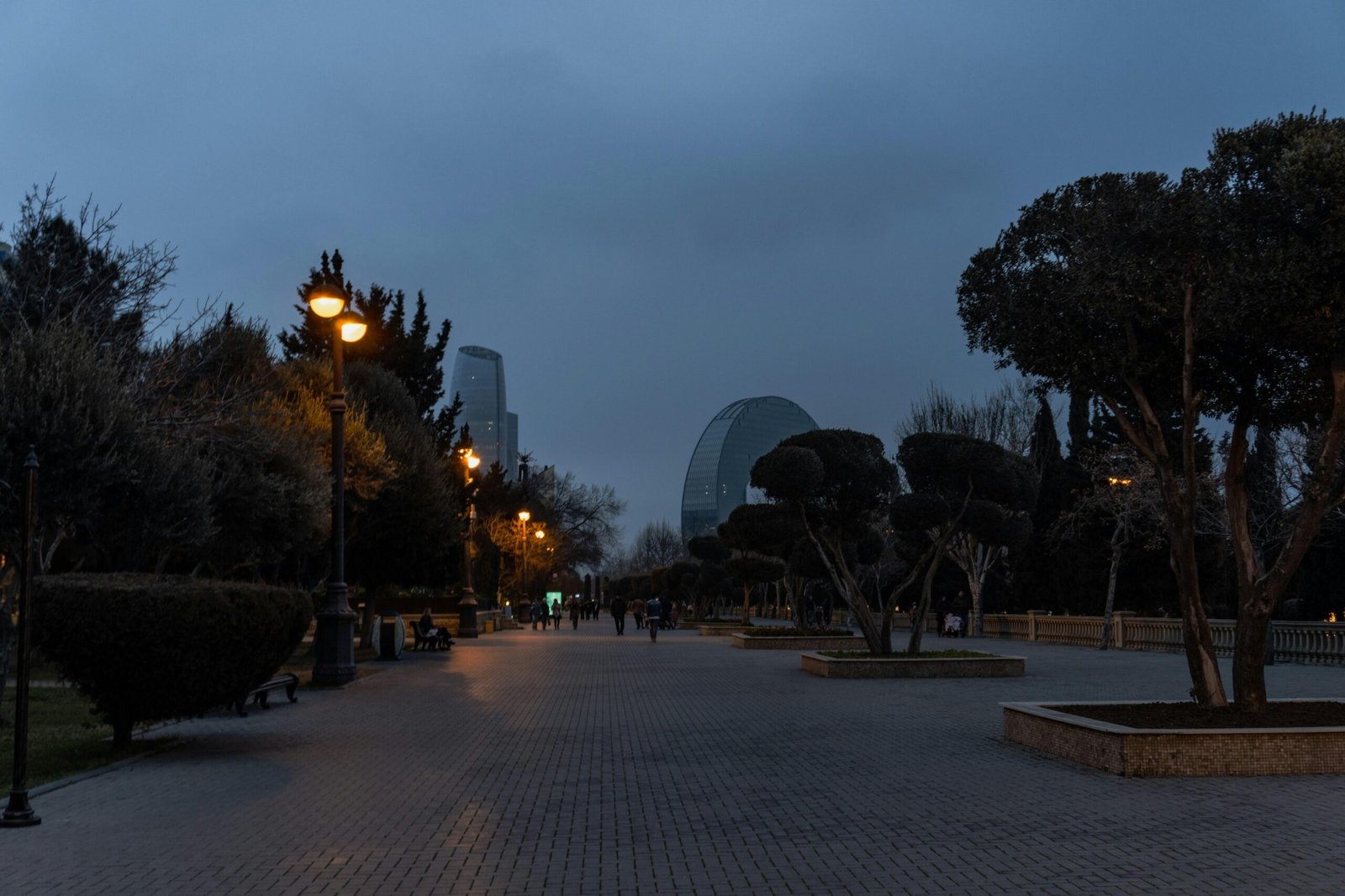 Parkweg mit Straßenlaternen und modernen Gebäuden bei Dämmerung auf Mallorca, aufgenommen von Zulfugar Karimov
