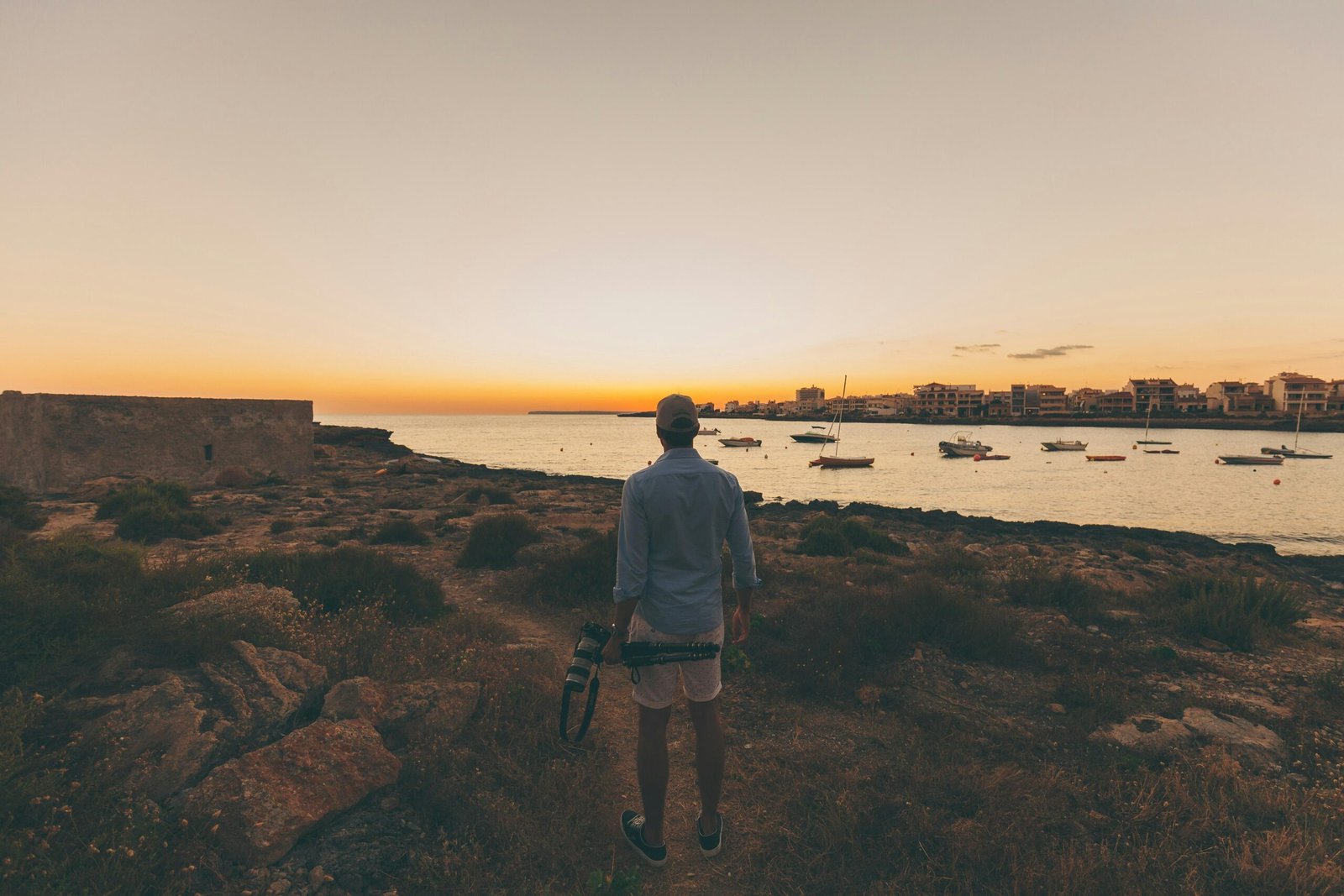Person steht in offener Landschaft auf Mallorca und blickt auf das Wasser, aufgenommen von Flo Dahm.