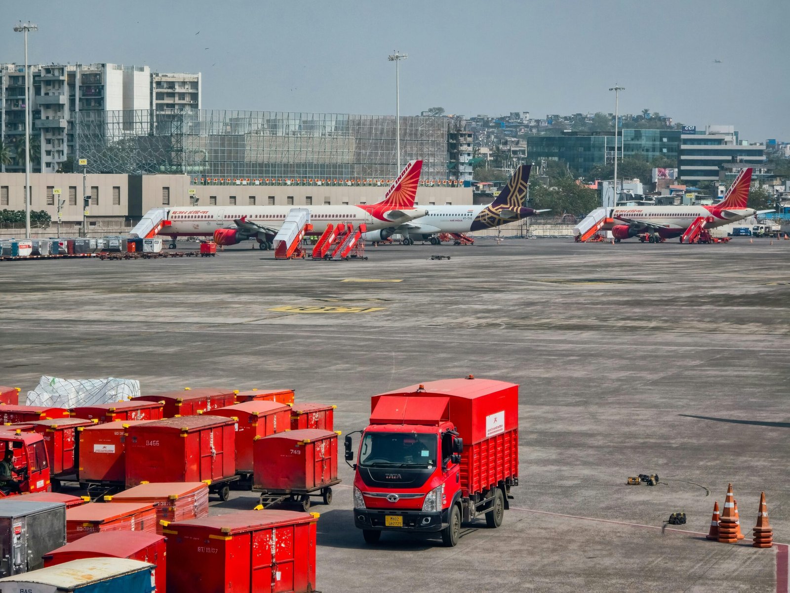 Rote Lastwagen und Flugzeuge auf dem Flughafengelände auf Mallorca, aufgenommen von Zoshua Colah.
