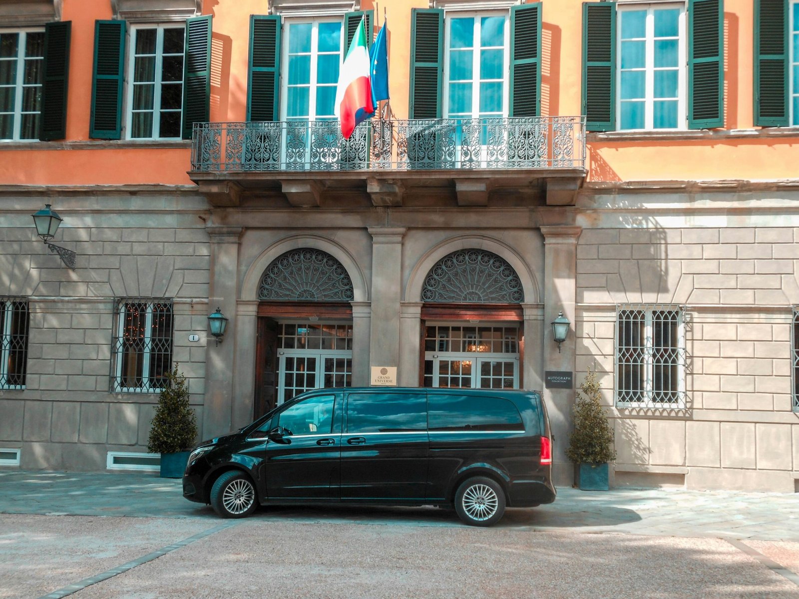 Schwarzer Limousine steht tagsüber neben einem braunen Backsteingebäude auf Mallorca, fotografiert von Gabriele Natali.